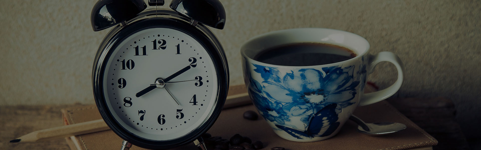 Fotografía detallada de un reloj de mesa junto a una taza de café.
